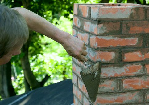 Trowel mending the joints along weathered brick